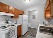 Thumbnail 4 of 32 - A kitchen with white appliances and wooden cabinets.