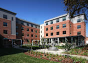 Thumbnail 1 of 23 - A modern building with a courtyard in front.