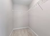 Thumbnail 7 of 7 - A white closet with a carpeted floor and a white shelf.
