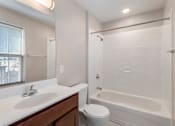 Thumbnail 5 of 7 - A white bathroom with a toilet, sink, and bathtub.