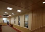 Thumbnail 10 of 23 - A long hallway with a red carpet and white walls.