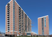Thumbnail 2 of 28 - A tall red brick building with balconies on the side.