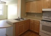 Thumbnail 12 of 23 - A kitchen with wooden cabinets and a white counter top.