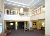 Thumbnail 21 of 26 - A large room with a carpeted floor and a chandelier hanging from the ceiling.