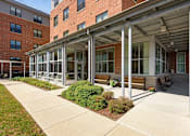 Thumbnail 16 of 23 - A building with a covered walkway and benches.