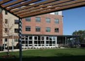Thumbnail 5 of 23 - A building with a red brick facade and a white framed porch.