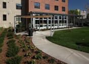Thumbnail 3 of 23 - A red brick building with a white trim and a white carport.