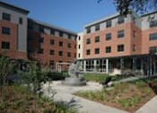 Thumbnail 4 of 23 - A building with a red brick facade and a white roof.