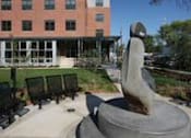 Thumbnail 6 of 23 - A statue of a woman is in front of a building.