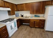 Thumbnail 18 of 28 - A kitchen with wooden cabinets and a white refrigerator.