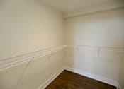 Thumbnail 25 of 28 - Empty room with white walls and wooden floor.