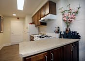 Thumbnail 15 of 28 - A kitchen with a white stove top oven and a white refrigerator.