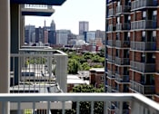 Thumbnail 8 of 28 - A cityscape is visible from a balcony.