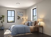 Thumbnail 5 of 11 - A bedroom with a bed, nightstand, and a plant.