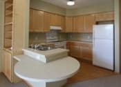 Thumbnail 13 of 23 - A kitchen with wooden cabinets and a white fridge.