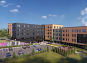 Thumbnail 3 of 10 - A modern apartment complex with a parking lot in front.