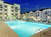 Thumbnail 5 of 12 - a swimming pool with lounge chairs and umbrellas next to a building at The Eddy at Riverview, Smyrna
