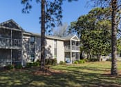 Thumbnail 10 of 23 - Apartment complex with trees in front.