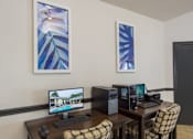 Thumbnail 15 of 23 - A room with a desk, computer, and two artworks on the wall.