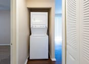 Thumbnail 23 of 23 - A white washing machine is in a small room.