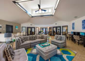Thumbnail 11 of 23 - A living room with a grey couch and a blue rug.