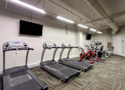 Thumbnail 5 of 23 - Gym with treadmills and bikes and a tv on the wall at 500 Fifth Apartments, Nashville, 37219