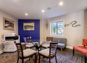 Thumbnail 17 of 23 - Living room with a dining room table and chairs and a kitchen with a microwave at 500 Fifth Apartments, Tennessee, 37219