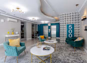 Thumbnail 13 of 23 - Living room with blue and yellow furniture and a lobby with a 50o sign at 500 Fifth Apartments, Nashville, TN