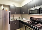 Thumbnail 21 of 23 - Kitchen with stainless steel appliances and granite counter tops at 500 Fifth Apartments, Tennessee