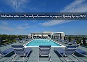 Thumbnail 2 of 23 - A swimming pool surrounded by lounge chairs on a rooftop.