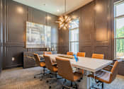 Thumbnail 37 of 37 - A conference room with a long table and chairs at The Ashton at East Park Apartments, Kennesaw, GA