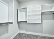 Thumbnail 28 of 37 - A white pantry with open shelves and a grey carpet at The Ashton at East Park Apartments, Georgia, 30144