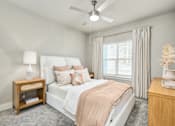 Thumbnail 22 of 37 - A bedroom with a bed, nightstand, and a ceiling fan at The Ashton at East Park Apartments, Kennesaw, GA, 30144