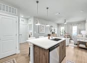 Thumbnail 24 of 37 - A modern kitchen with a large island and a dining area at The Ashton at East Park Apartments, Kennesaw, 30144