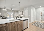 Thumbnail 2 of 37 - A modern kitchen with wooden cabinets and stainless steel appliances at The Ashton at East Park Apartments, Kennesaw, GA