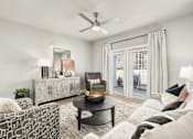 Thumbnail 1 of 37 - A living room with a black coffee table and a grey sofa at The Ashton at East Park Apartments, Kennesaw, GA, 30144
