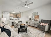 Thumbnail 4 of 37 - A modern living room with a grey sofa and a black coffee table at The Ashton at East Park Apartments, Kennesaw, Georgia