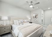 Thumbnail 19 of 37 - A bedroom with a large bed and a ceiling fan at The Ashton at East Park Apartments, Kennesaw