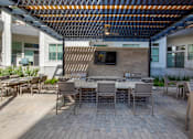 Thumbnail 26 of 47 - Patio with tables and chairs and a fireplace at The Monroe Apartments, Austin, 78741