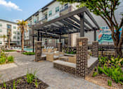 Thumbnail 23 of 47 - Patio with lounge furniture and a pool at an apartment building at The Monroe Apartments, Texas, 78741