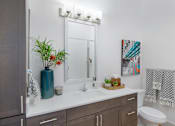 Thumbnail 17 of 47 - a bathroom with a sink and a mirror and a toilet at The Monroe Apartments, Austin, Texas