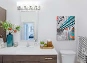 Thumbnail 16 of 47 - Bathroom with a sink and a toilet and a mirror at The Monroe Apartments, Austin, Texas