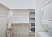 Thumbnail 18 of 47 - a laundry room with a washer and dryer and a closet with hangers at The Monroe Apartments, Texas, 78741