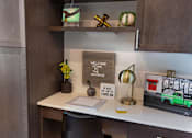 Thumbnail 11 of 47 - a desk with a laptop and a lamp on it at The Monroe Apartments, Austin, 78741