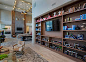 Thumbnail 33 of 47 - a living room with a large book shelf and a television at The Monroe Apartments, Austin, Texas