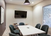 Thumbnail 39 of 47 - a conference room with a table and chairs and a tv on the wall at The Monroe Apartments, Austin, 78741