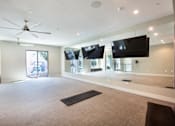 Thumbnail 45 of 47 - a large living room with a ceiling fan and televisions at The Monroe Apartments, Austin