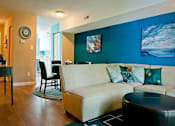 Thumbnail 4 of 14 - Living room with a blue accent wall at Emory Woods Apartments, Durham, North Carolina.