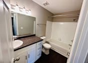 Thumbnail 21 of 23 - A bathroom with a toilet, sink, and bathtub.