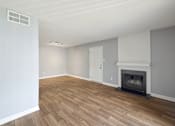 Thumbnail 9 of 15 - an empty living room with a fireplace and wooden floors  at Governors House, Alabama